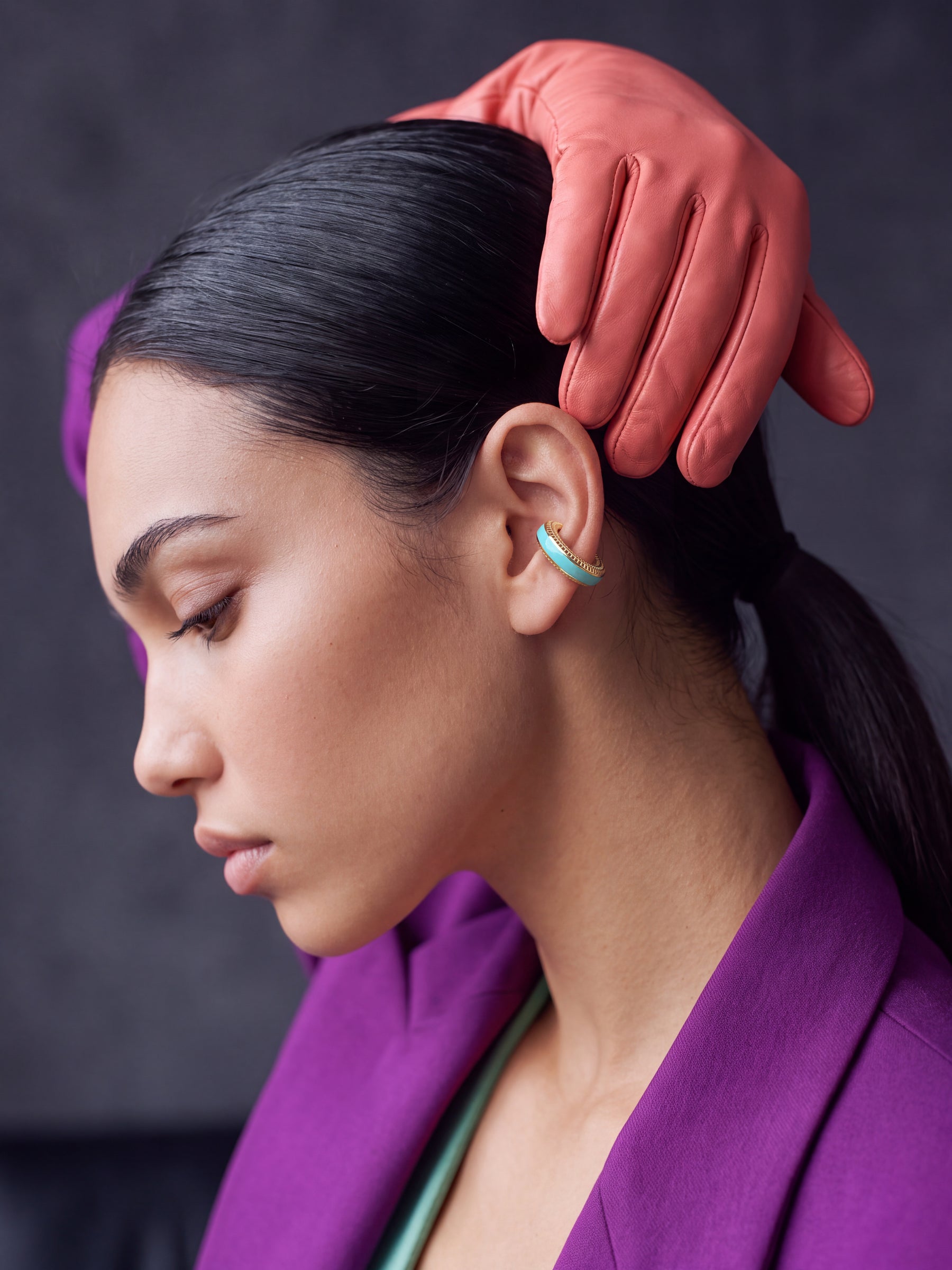 Aqua Insight aqua blue enamel gold-plated ear cuff on a model in a purple blazer with leather gloves