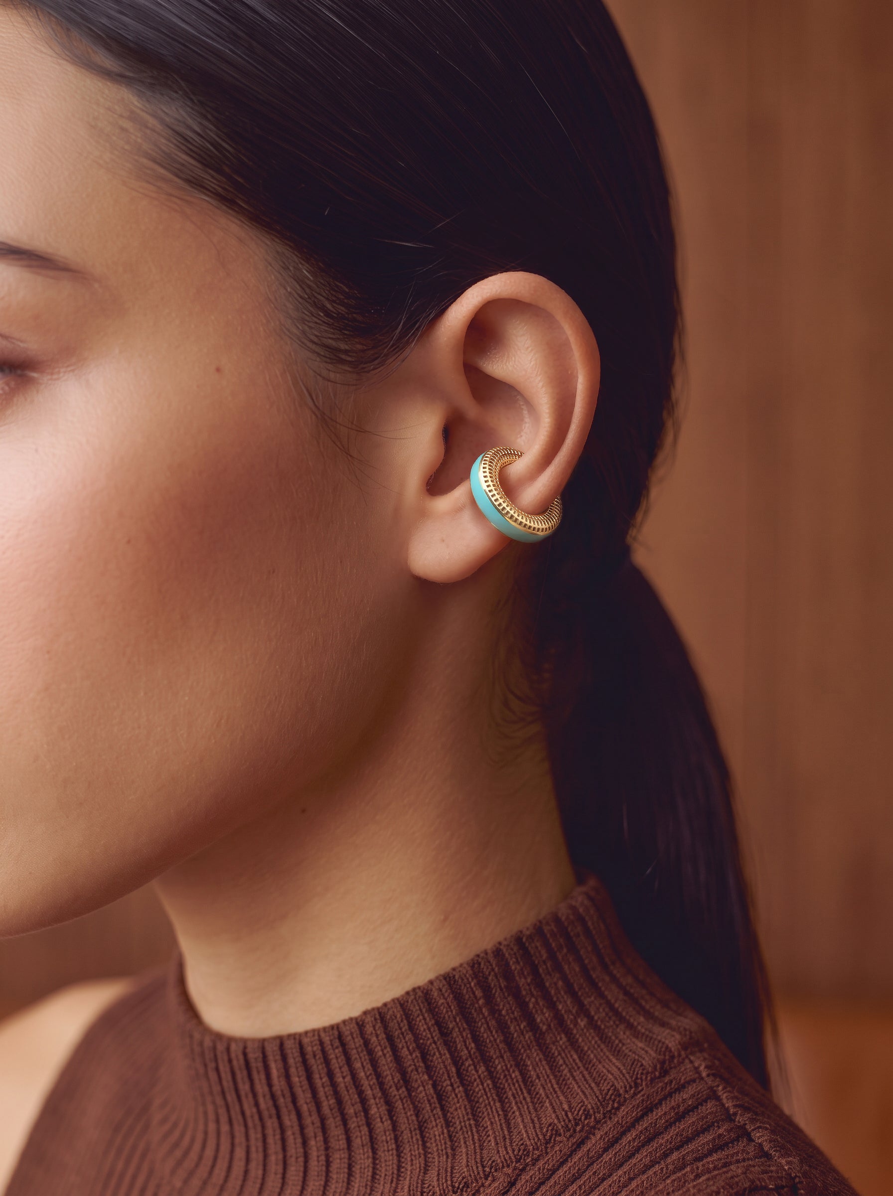 Aqua Insight aqua blue enamel gold-plated ear cuff, close-up on the ear