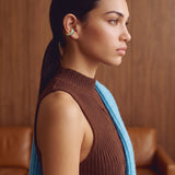 Model wearing the Aqua Insight gold-plated ear cuff with a brown mock-neck knit, side view