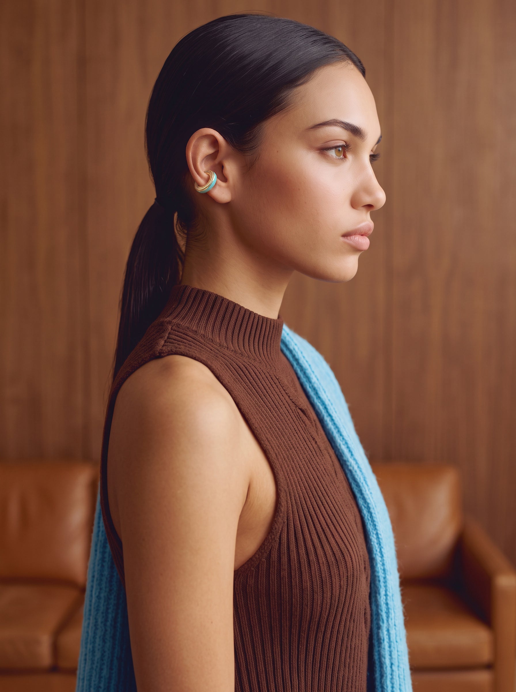 Model wearing the Aqua Insight gold-plated ear cuff with a brown mock-neck knit, side view