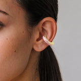 Blush Serenity 14K gold-plated ear cuff with powder pink enamel, close-up on the ear