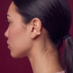 Blush Serenity 14K gold-plated ear cuff on a model in a pink sweater, profile view