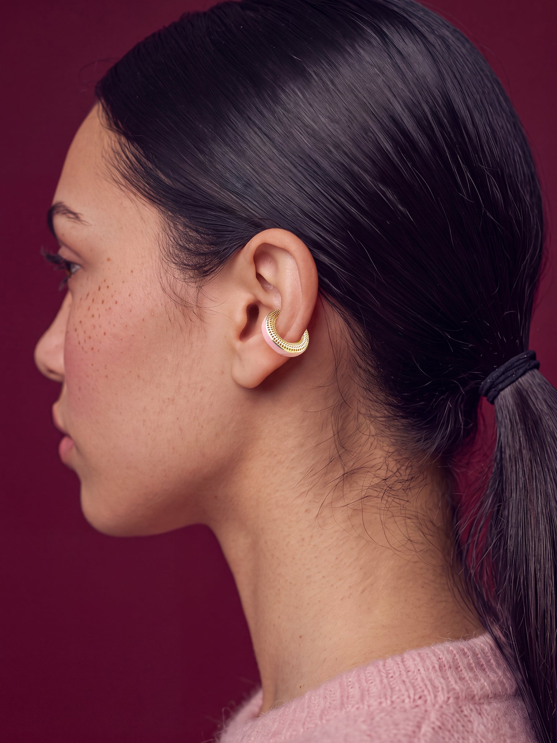 Blush Serenity 14K gold-plated ear cuff on a model in a pink sweater, profile view