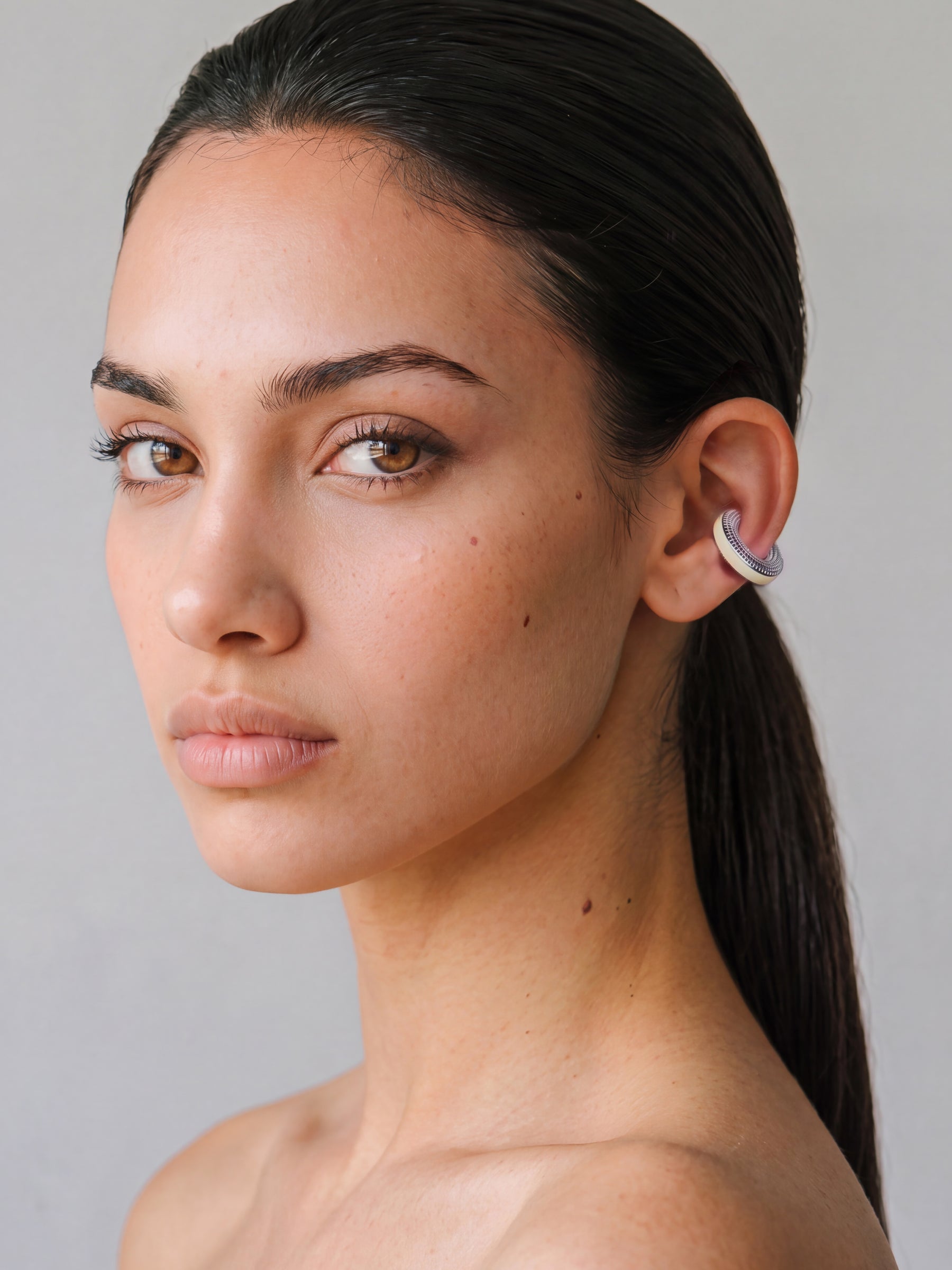 Model wearing the Hola Aura silver ear cuff with butter yellow enamel, minimal portrait