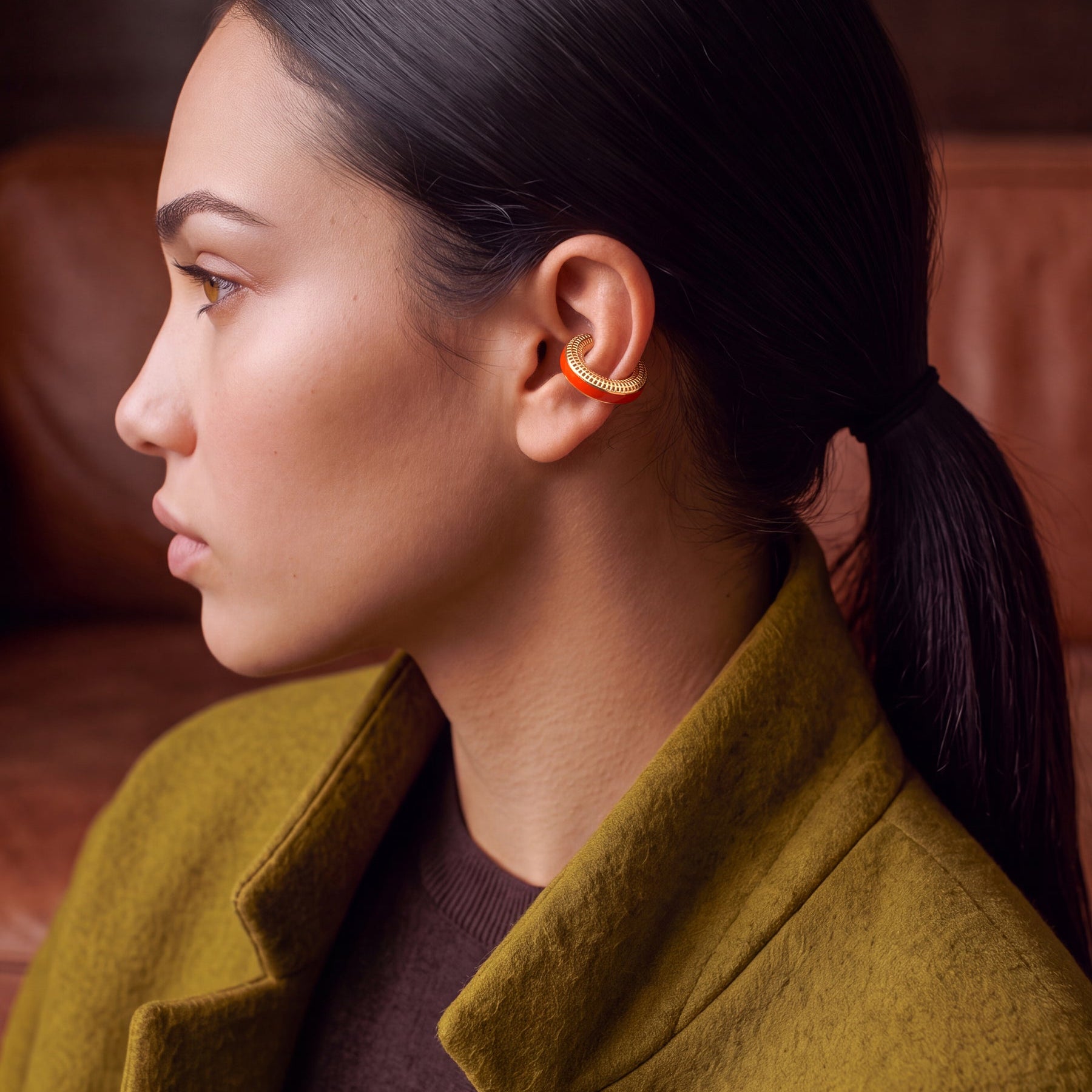 Ignite Pulse ear cuff kulakta yakın çekim, ateş turuncusu mine, 14 ayar altın kaplama 925 ayar gümüş deliksiz kıkırdak küpe, haki paltolu model