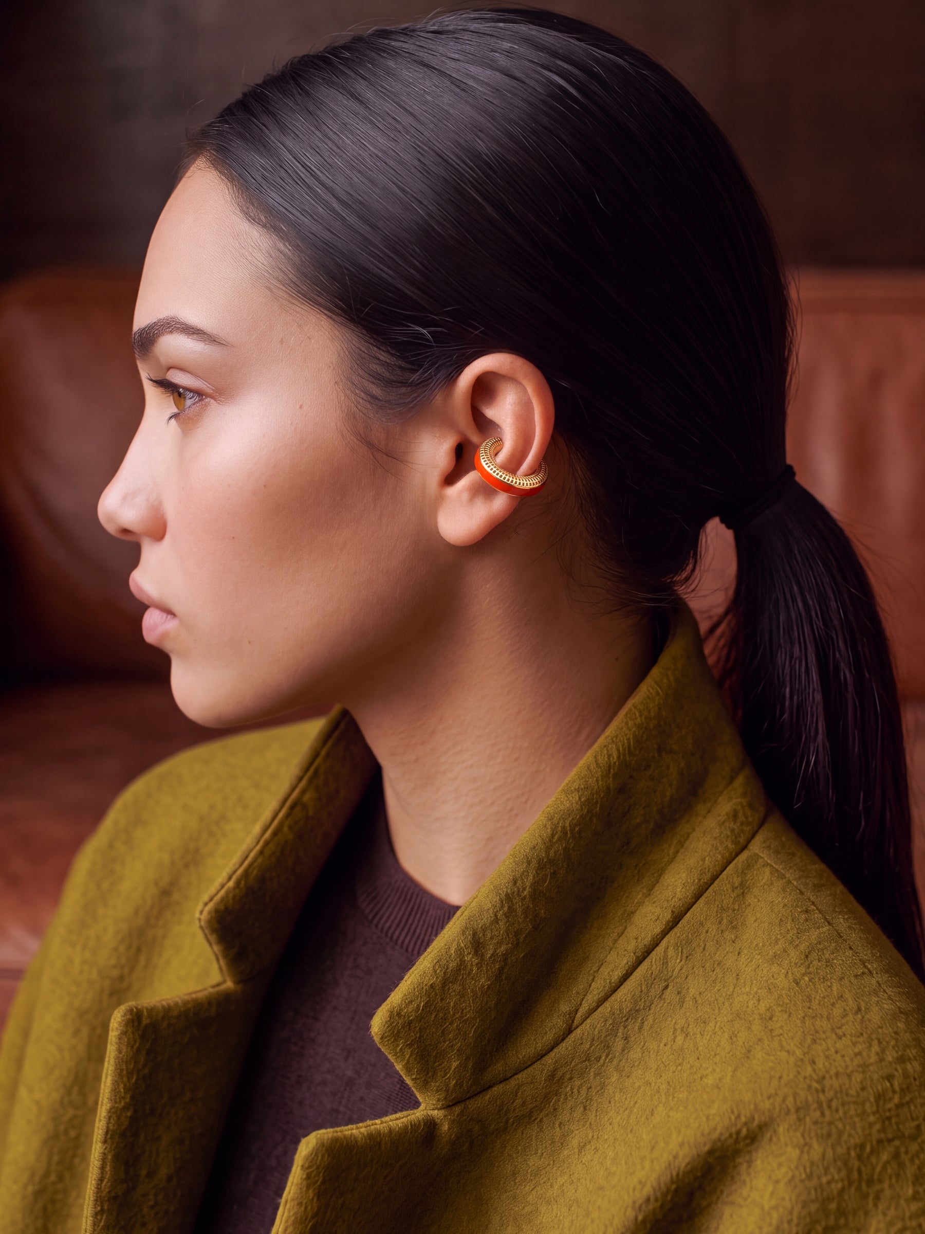 Ignite Pulse ear cuff kulakta yakın çekim, ateş turuncusu mine, 14 ayar altın kaplama 925 ayar gümüş deliksiz kıkırdak küpe, haki paltolu model