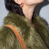 Ignite Pulse orange enamel silver earring worn with a green faux fur coat