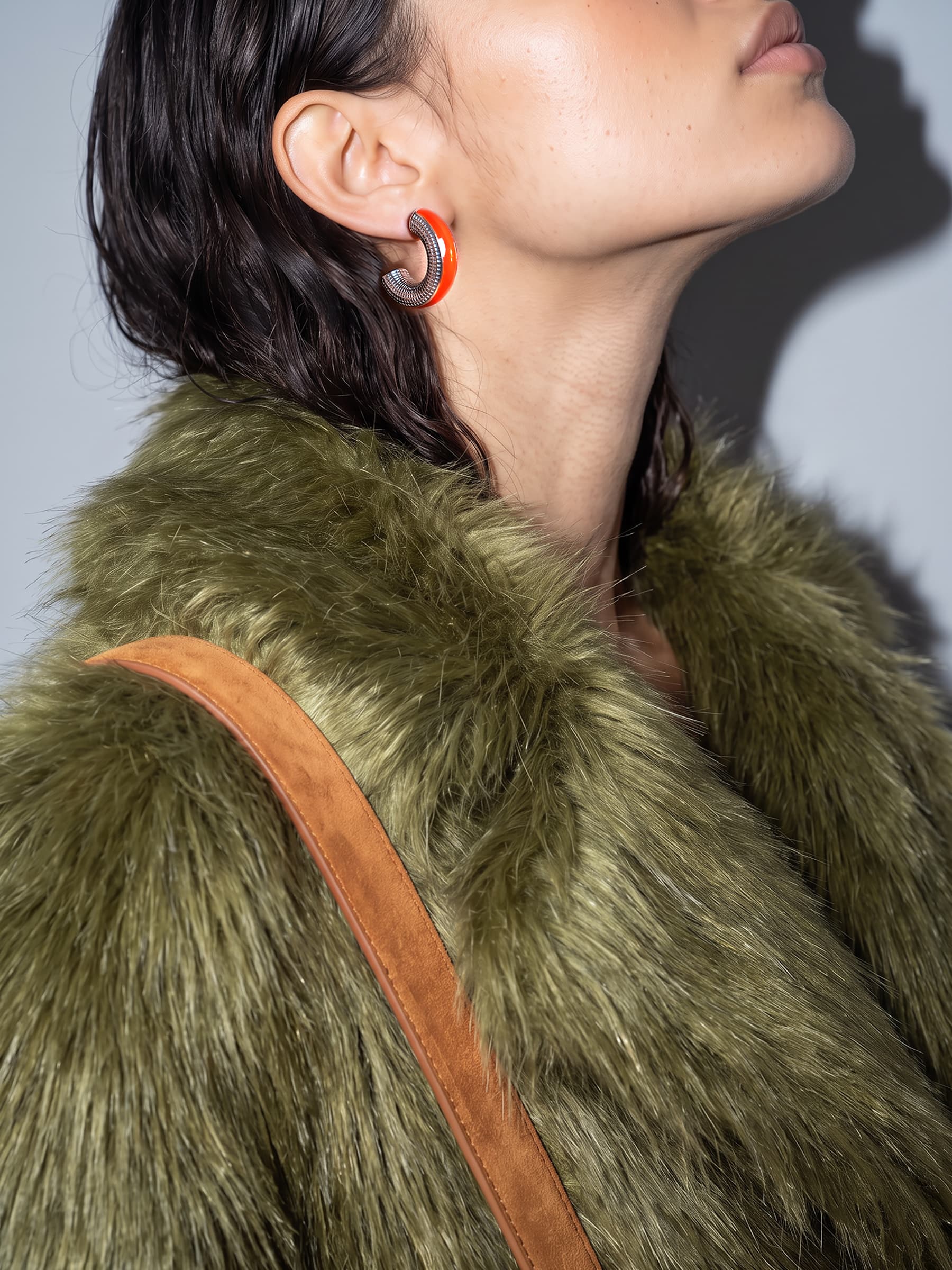 Ignite Pulse orange enamel silver earring worn with a green faux fur coat