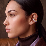 Lilac Reverie 14K gold-plated ear cuff on a model in a brown turtleneck, profile view