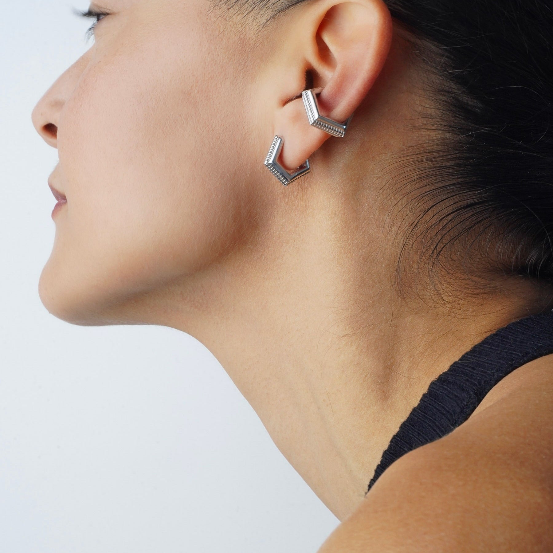 Model wearing Mini Verta Earrings and an ear cuff, profile view, black top