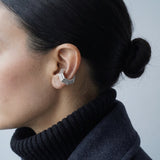 Model wearing the Octa Ear Cuff with a charcoal wool coat and black turtleneck, editorial shot