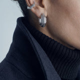 Octavia earrings – layered octagonal hoop in rhodium-plated 925 sterling silver worn with an ear cuff and a navy coat