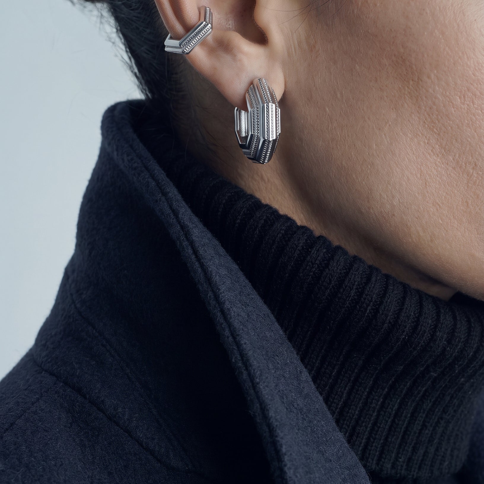 Octavia earrings – layered octagonal hoop in rhodium-plated 925 sterling silver worn with an ear cuff and a navy coat