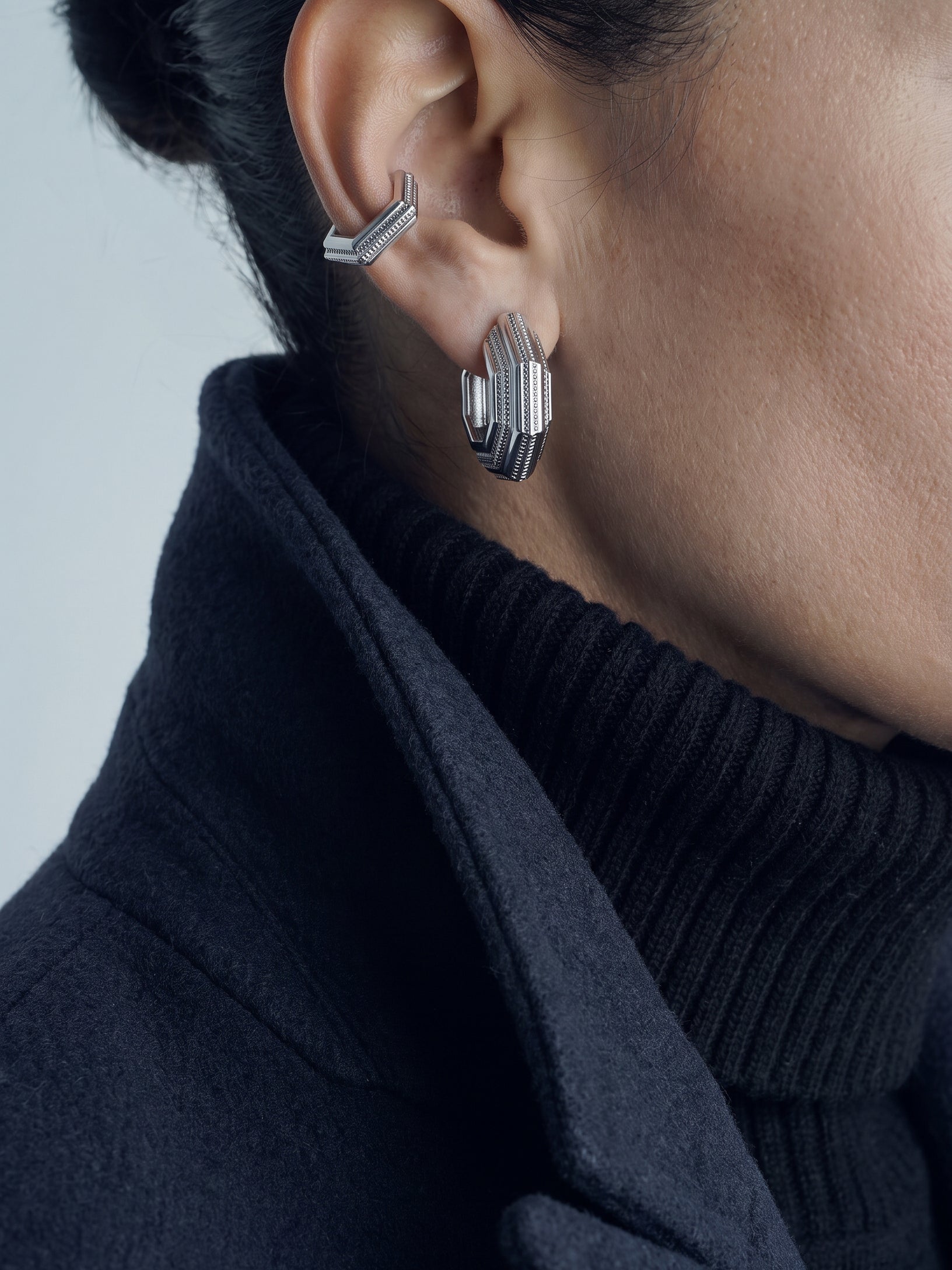Octavia earrings – layered octagonal hoop in rhodium-plated 925 sterling silver worn with an ear cuff and a navy coat