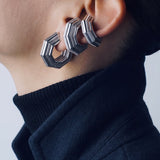 Octavia earring stacked with two UNBOUND ear cuffs, navy coat