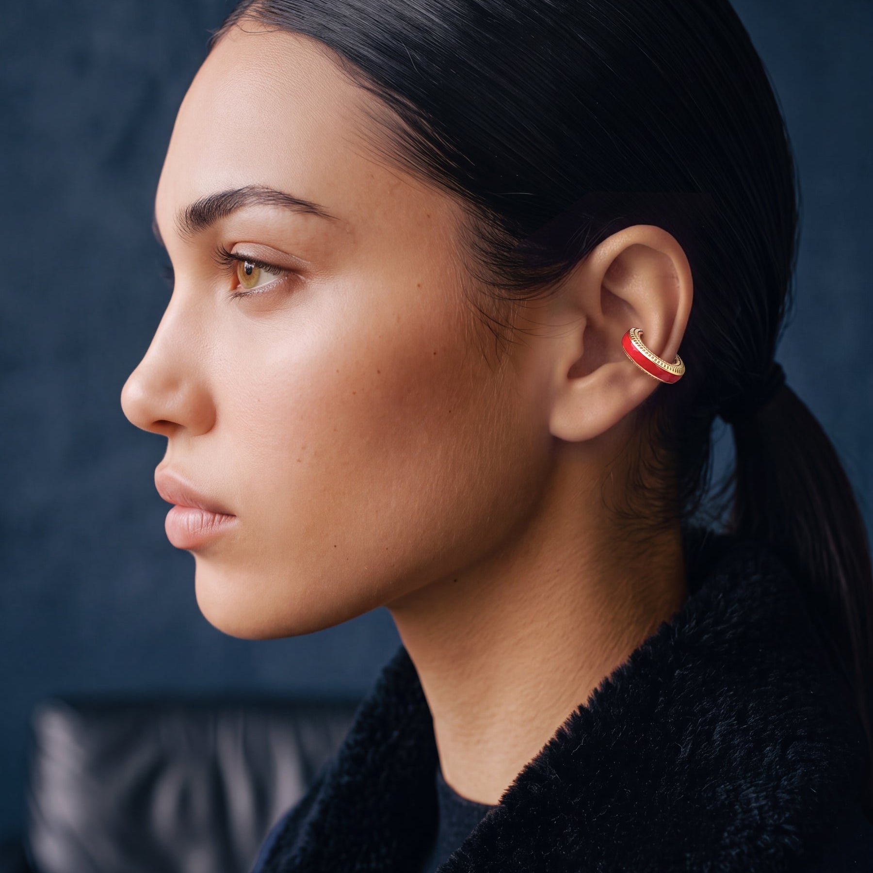 Scarlet Pulse 14K gold-plated ear cuff on a model in a navy jacket, profile view