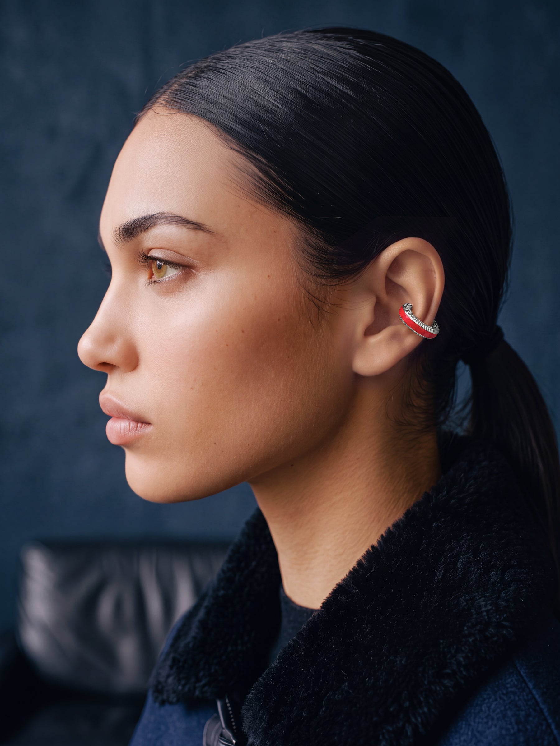 Scarlet Pulse silver ear cuff with red enamel on a model in a navy jacket, profile view