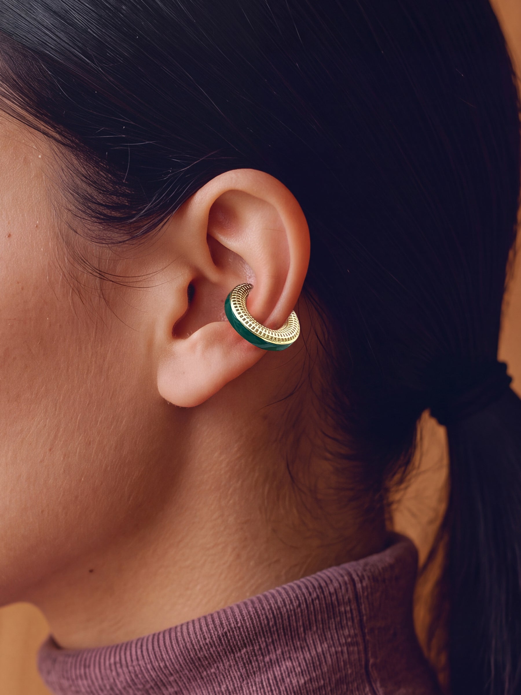 Verdant Poise 14K gold-plated ear cuff with green enamel, close-up on the ear
