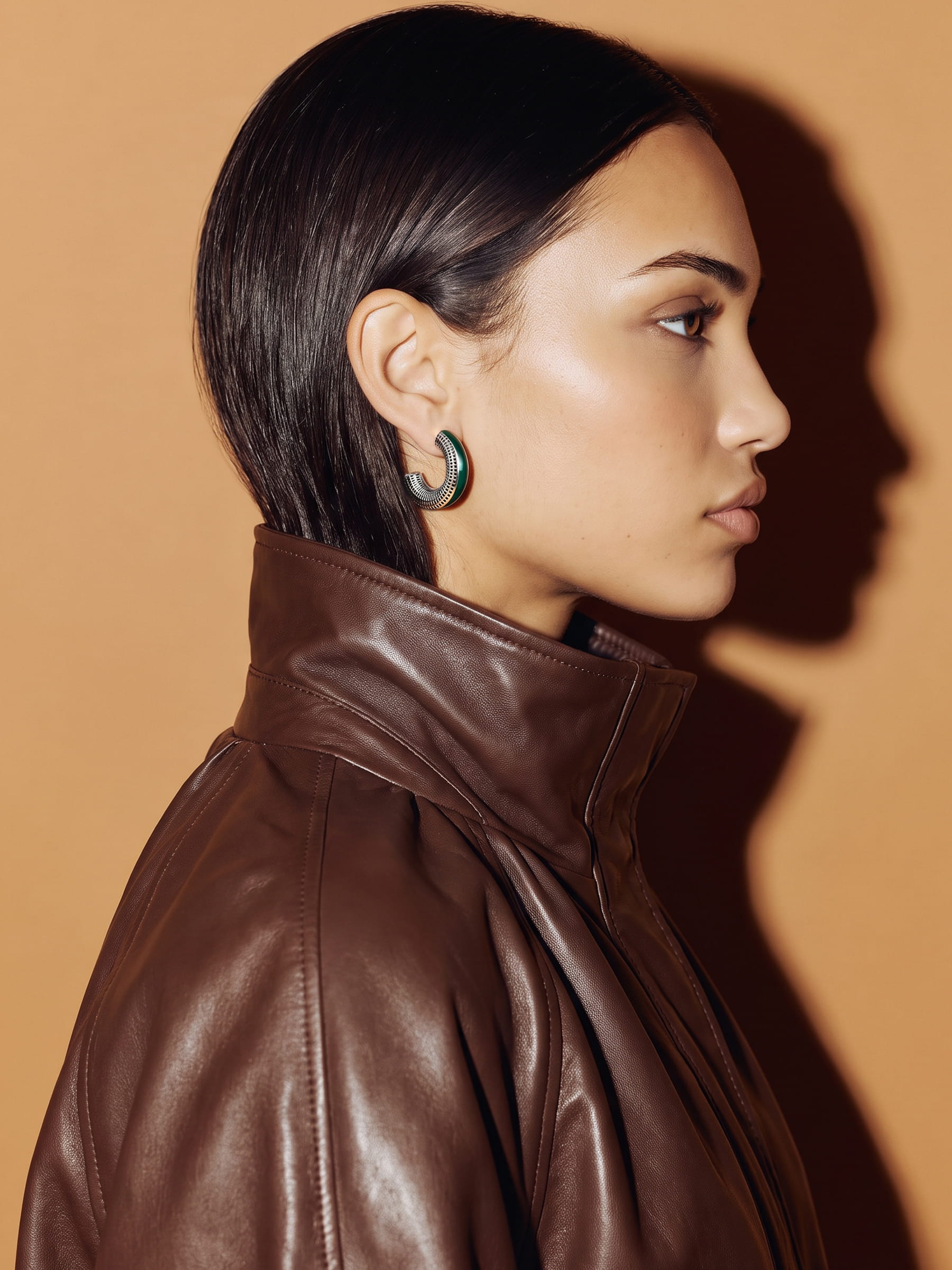 Verdant Poise green enamel silver earring, profile view of a model in a brown leather jacket