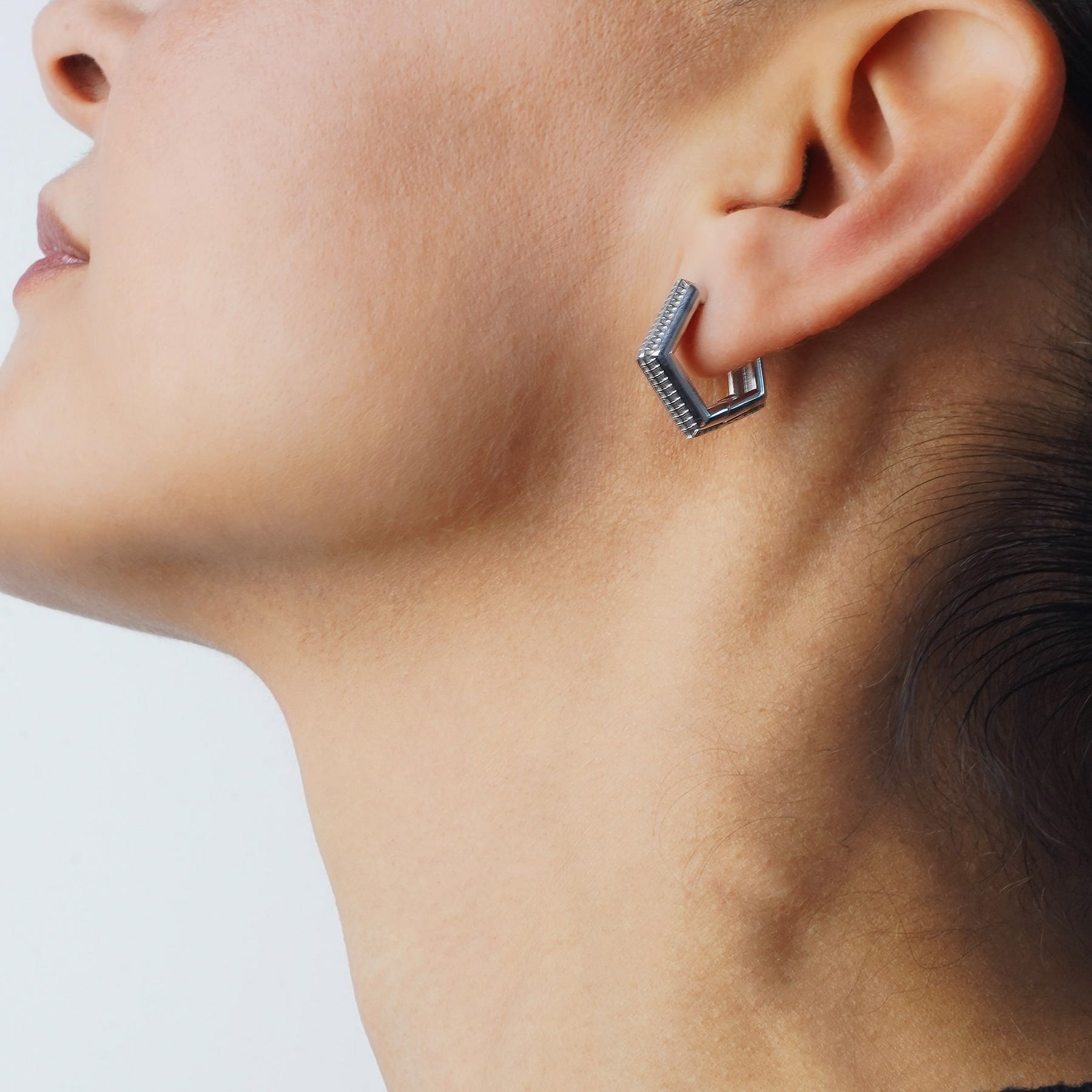 Model wearing Verta Earrings, profile view, black top